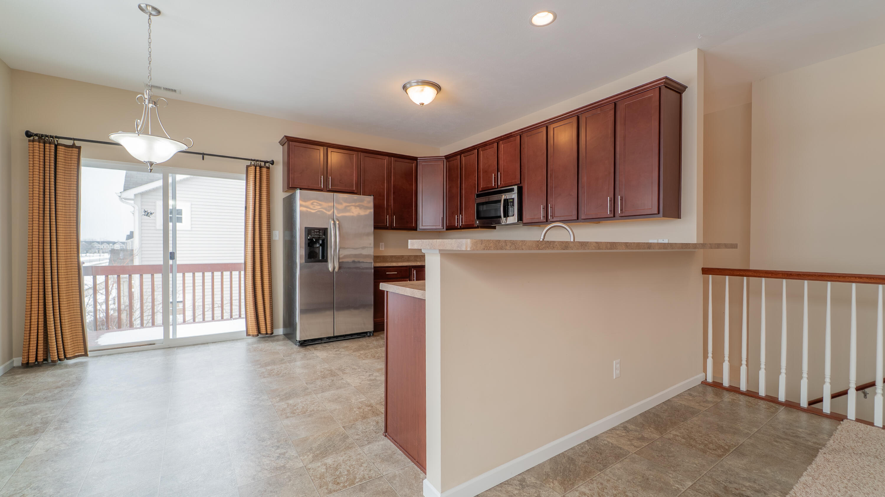 11530 Vermont Court Crown Point, IN 46307 - Photo 8 of 27 a view of a kitchen with a refrigerator a microwave oven a sink and a refrigerator