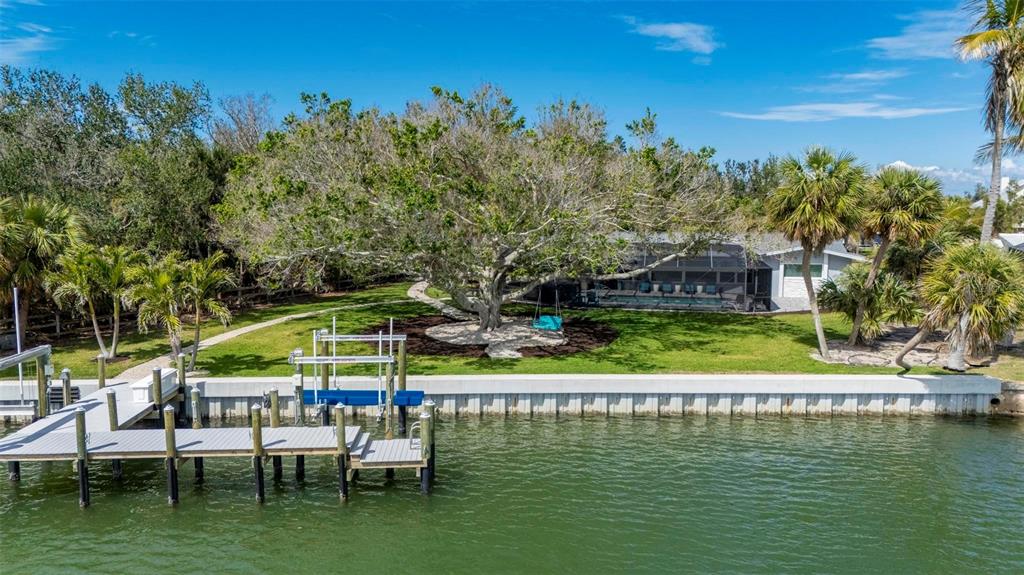 75 Spyglass Alley Placida, FL 33946 - Photo 75 of 79 a view of a lake with a table and chairs under an umbrella