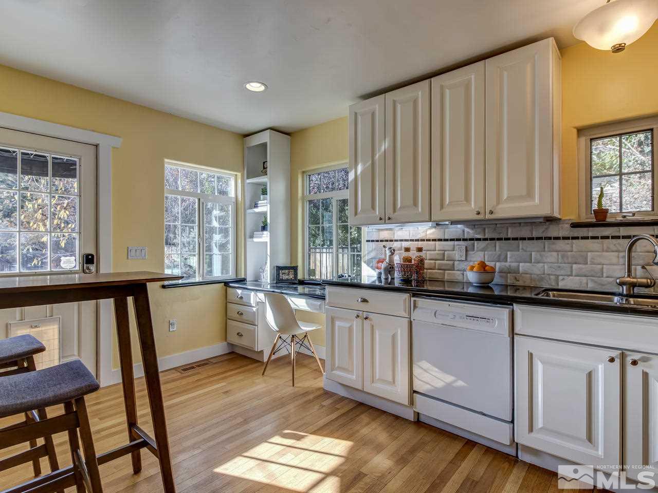 950 Walker Avenue Reno, NV 89509 - Photo 11 of 25 a kitchen with granite countertop wooden cabinets a sink a stove a dining table and chairs