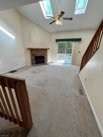 a view of an empty room with a fireplace and a window