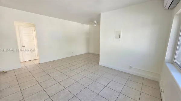 an empty room with a fireplace and windows