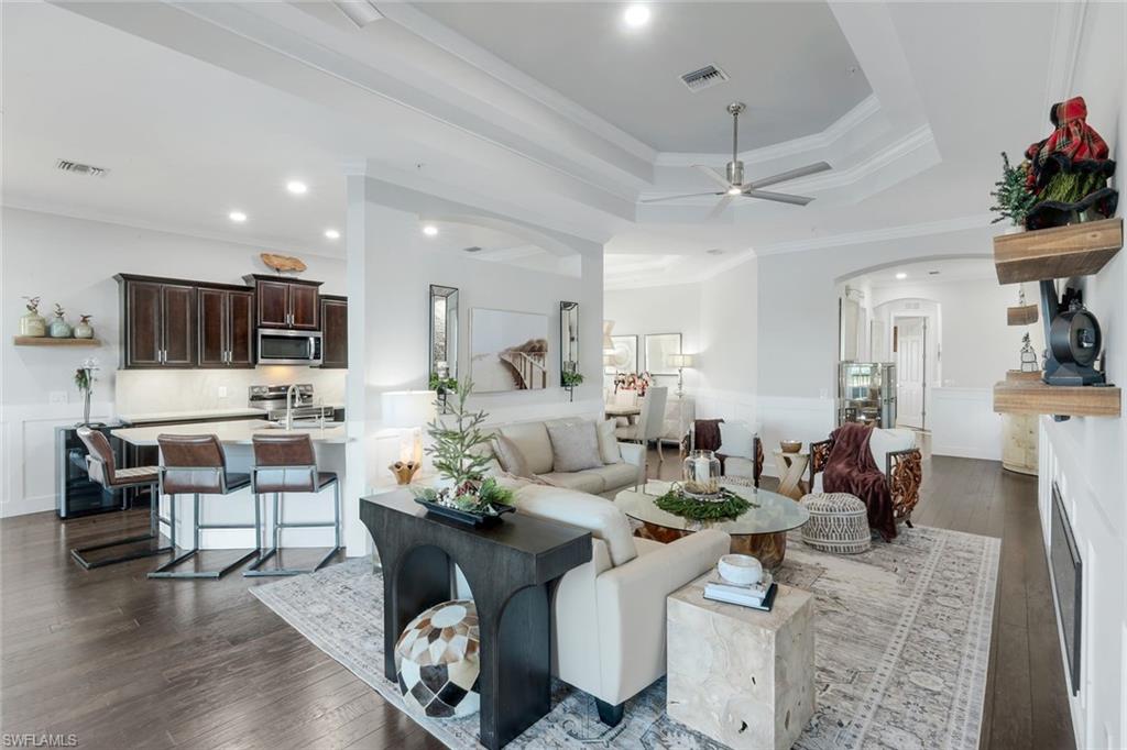 8783 Coastline Court, Unit 202 Naples, FL 34120 - Photo 11 of 49 a living room with fireplace furniture and a wooden floor