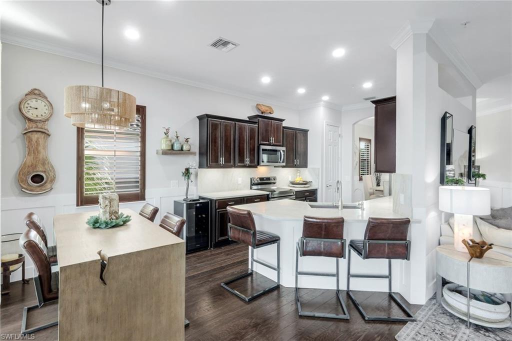 8783 Coastline Court, Unit 202 Naples, FL 34120 - Photo 12 of 49 a large kitchen with a table and chairs