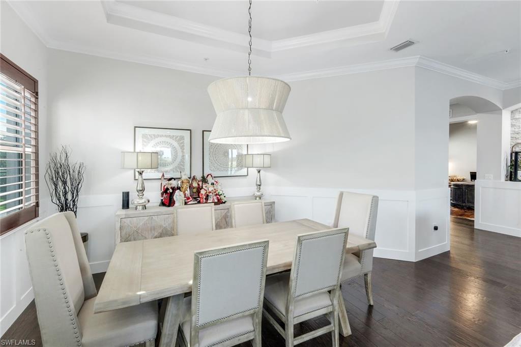 8783 Coastline Court, Unit 202 Naples, FL 34120 - Photo 19 of 49 a view of a dining room with furniture wooden floor and chandelier