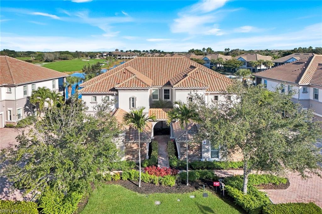 8783 Coastline Court, Unit 202 Naples, FL 34120 - Photo 2 of 49 a front view of a house with a garden