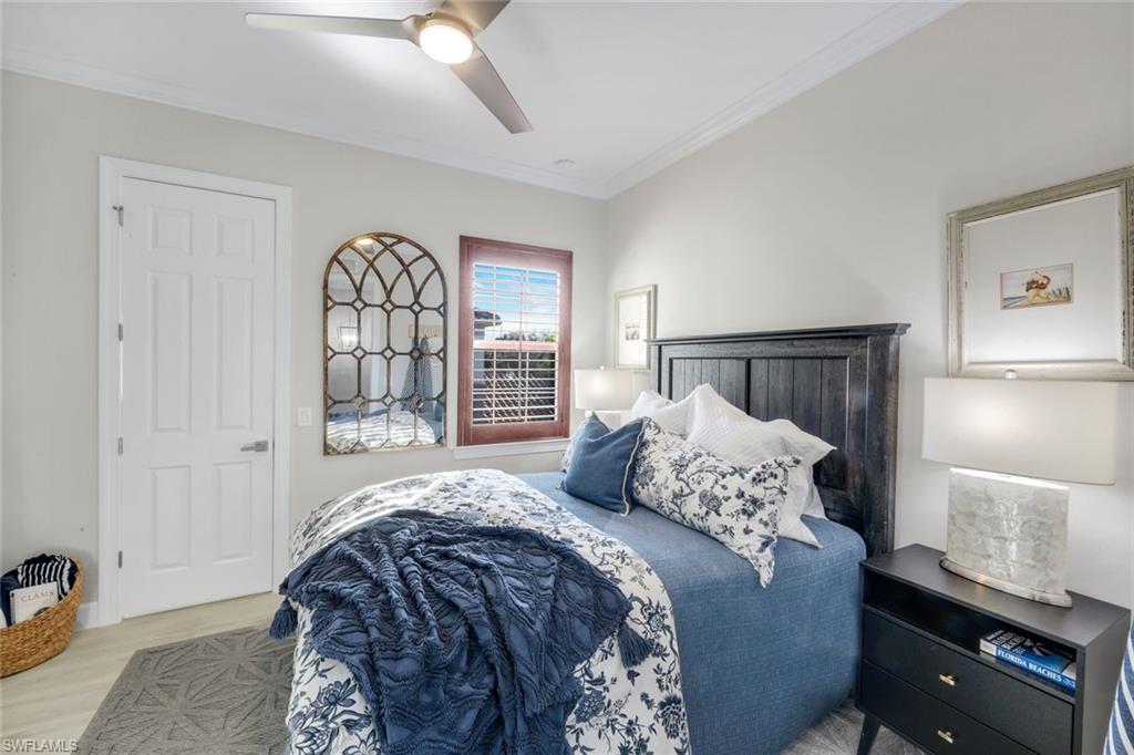 8783 Coastline Court, Unit 202 Naples, FL 34120 - Photo 26 of 49 a bedroom with a bed and a night stand