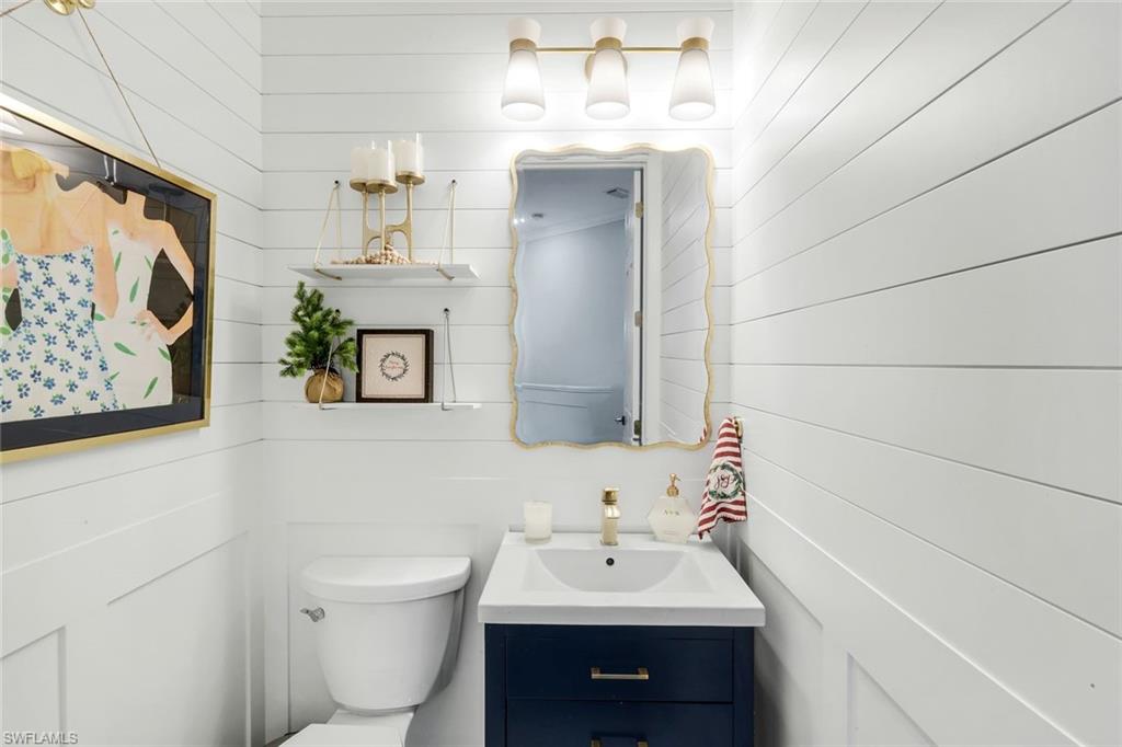 8783 Coastline Court, Unit 202 Naples, FL 34120 - Photo 27 of 49 a bathroom with a toilet sink and mirror