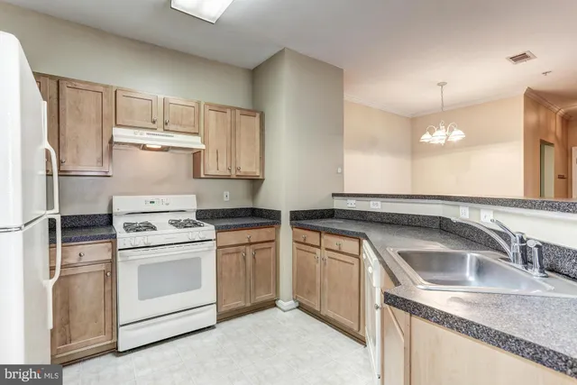 a kitchen with stainless steel appliances granite countertop a refrigerator sink and stove