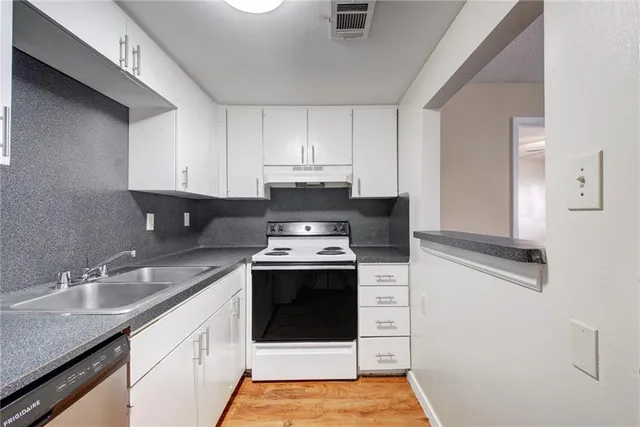 a kitchen with stainless steel appliances granite countertop a sink stove and cabinets