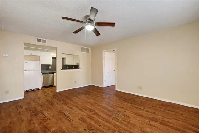a view of a kitchen with a sink and refrigerator