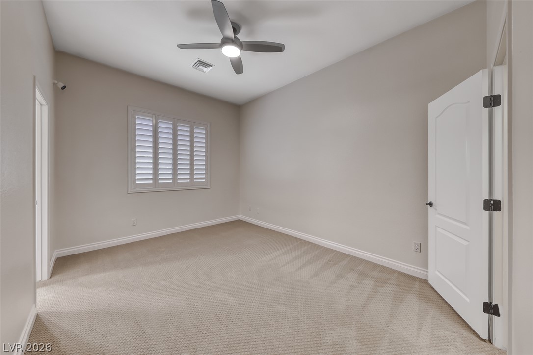 2122 Mooreview Street Henderson, NV 89012 - Photo 27 of 44 A well-lit bedroom features plush carpeting and a ceiling fan for comfort.