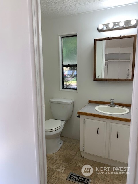 6800 North Enterprise Road, Unit 24 Ferndale, WA 98248 - Photo 12 of 18 a bathroom with a toilet a sink and mirror
