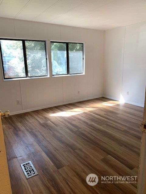 6800 North Enterprise Road, Unit 24 Ferndale, WA 98248 - Photo 9 of 18 an empty room with wooden floor and windows