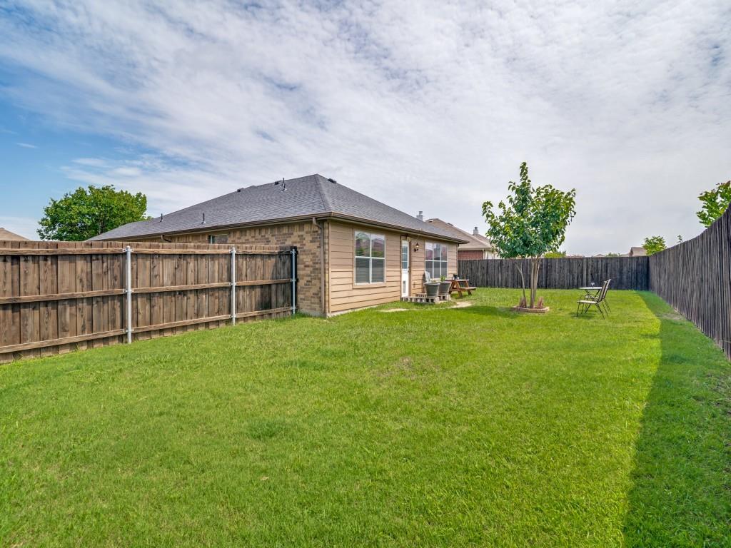 119 Robin Lane Forney, TX 75126 - Photo 25 of 27 Expansive backyard featuring a lush lawn, privacy fencing, and a mature tree