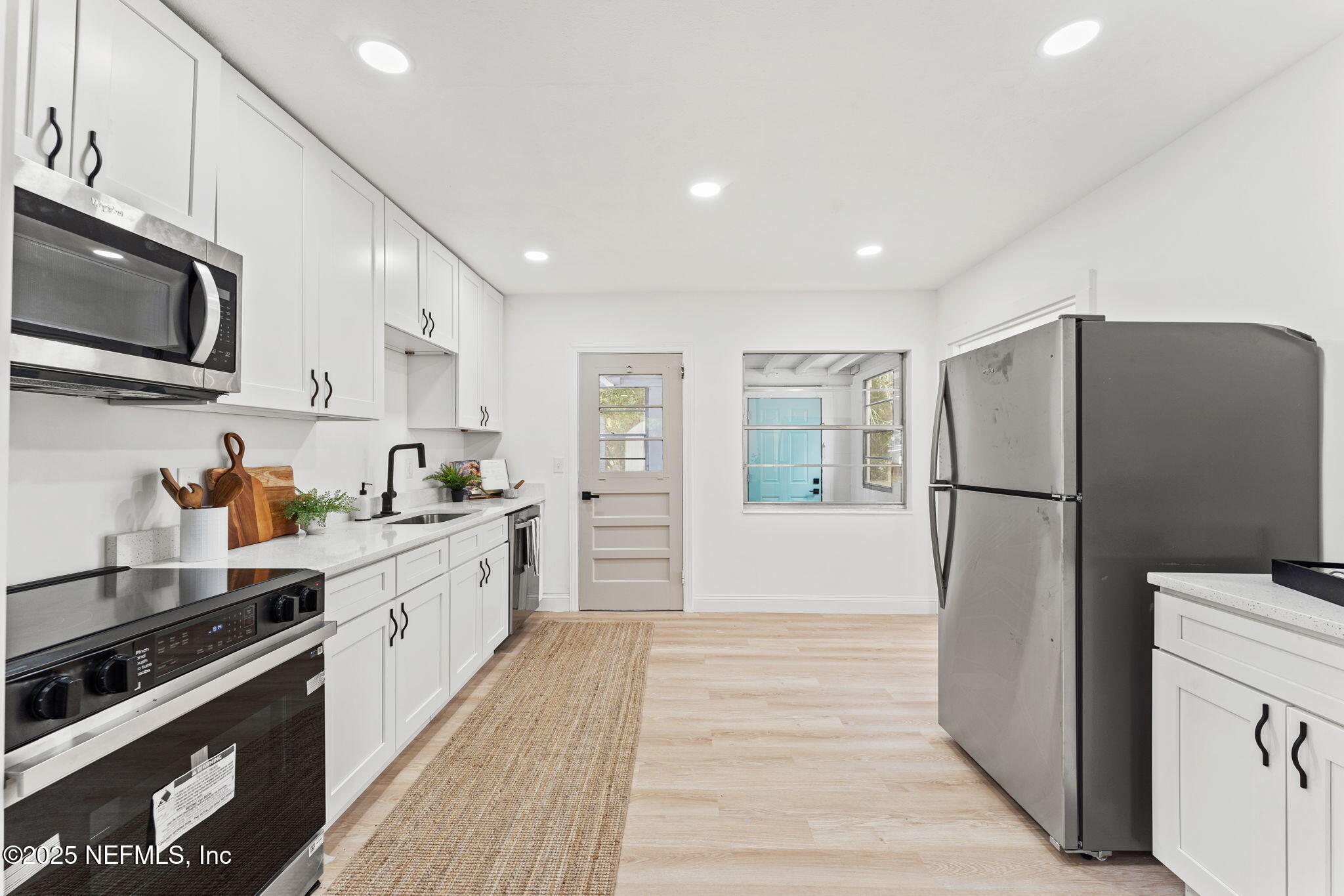 1436 Forest Hills Road Jacksonville, FL 32208 - Photo 11 of 27 a kitchen with stainless steel appliances a refrigerator stove microwave and sink