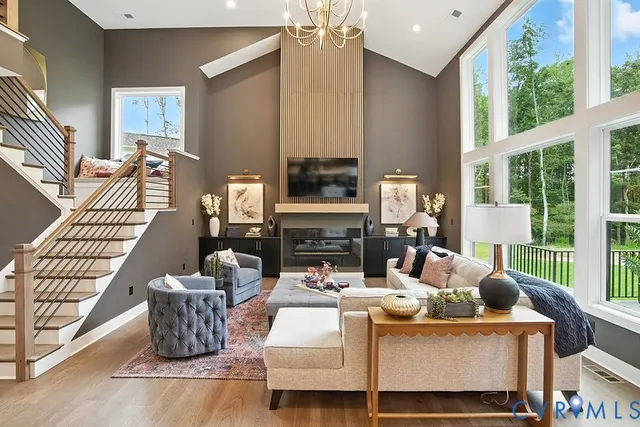 a living room with furniture a fireplace and a floor to ceiling window