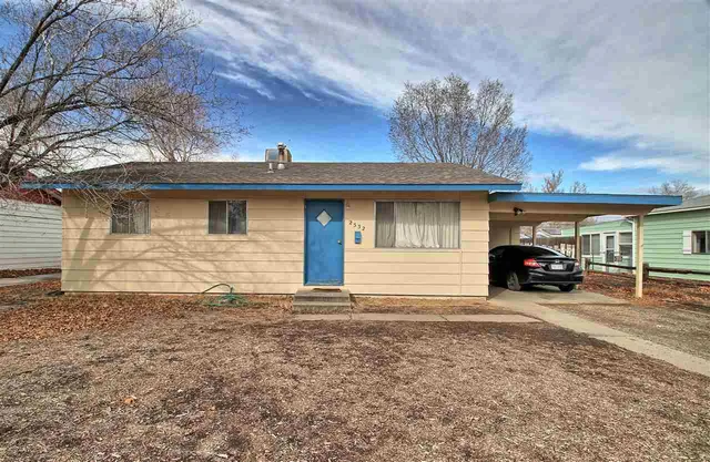 a front view of a house with large trees