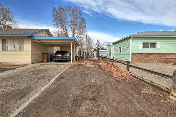 a view of a house with a yard and parking space