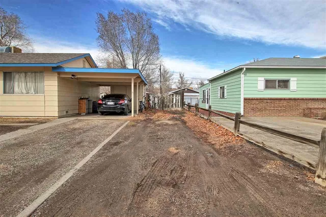 a view of a house with a yard and parking space