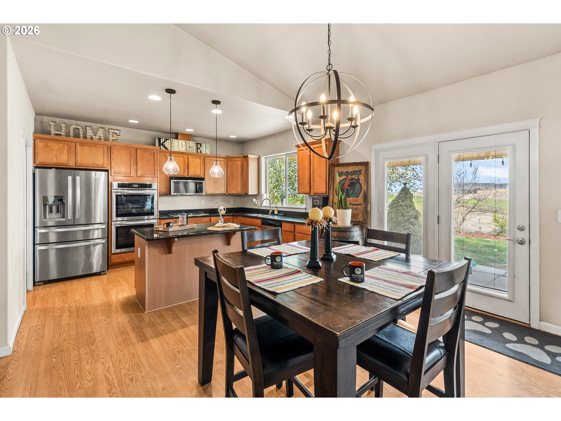 77286 Joyce Way Echo, OR 97826 - Photo 9 of 41 a kitchen with stainless steel appliances granite countertop a sink a stove a kitchen island with chairs and wooden floor