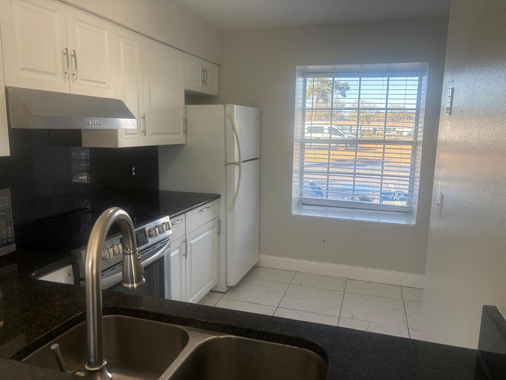3216 Hempstead Avenue Kissimmee, FL 34741 - Photo 5 of 13 a kitchen with a refrigerator and a sink