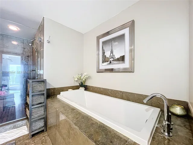 a bathroom with a tub and a view of bathroom