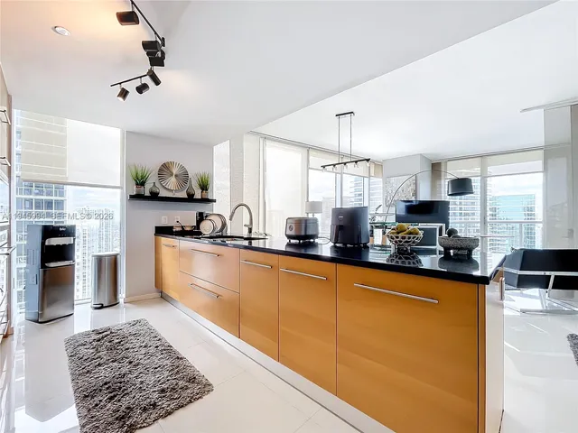 a kitchen with granite countertop a sink cabinets and stainless steel appliances