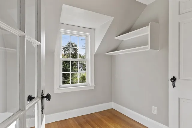 a view of a hallway with wooden floor and staircase