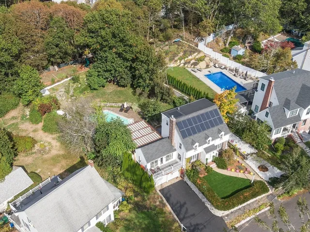 an aerial view of residential houses with outdoor space and trees