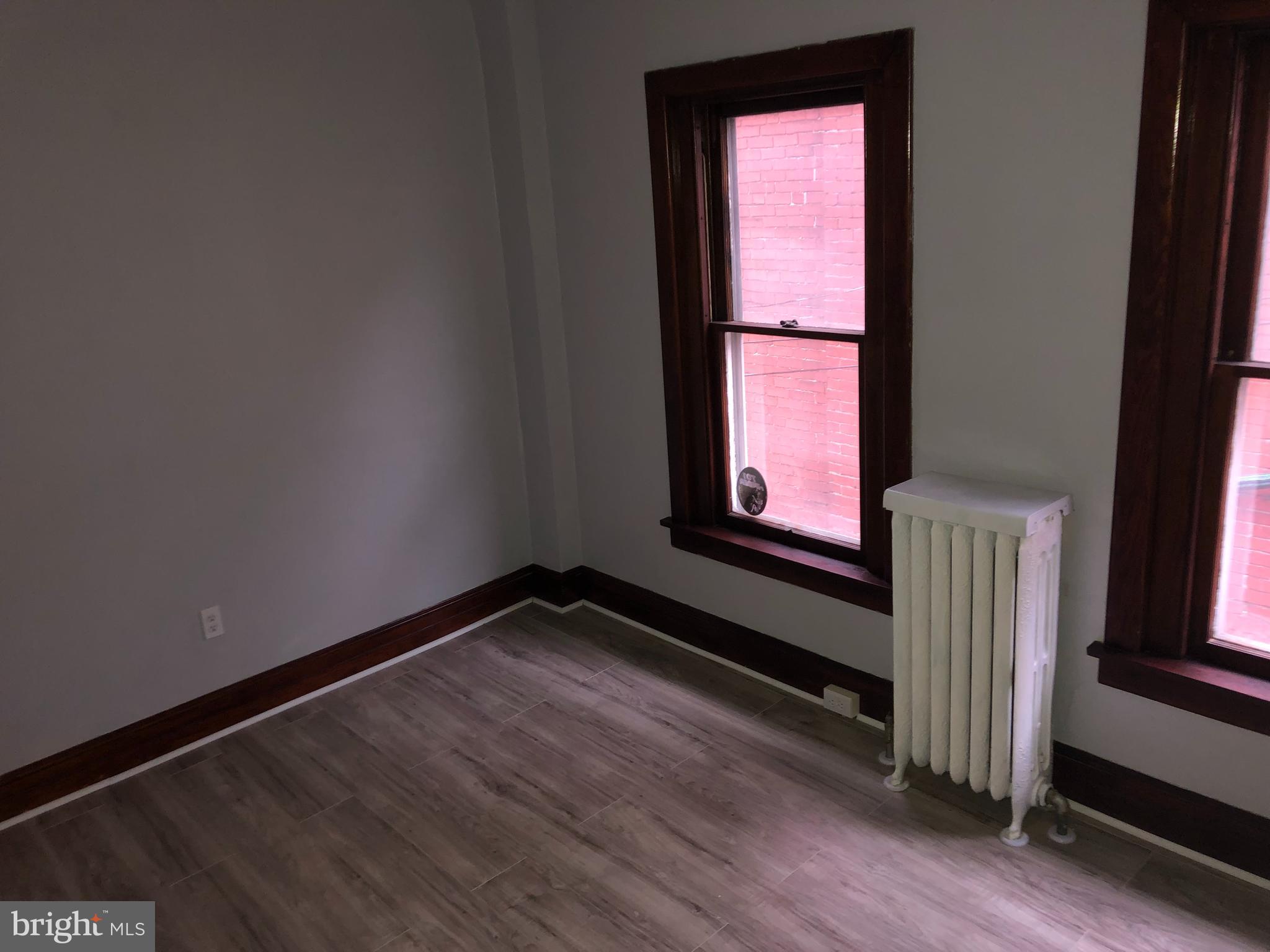 607 Guilford Street, Unit 2 Lebanon, PA 17046 - Photo 8 of 9 a view of an empty room with wooden floor and a window