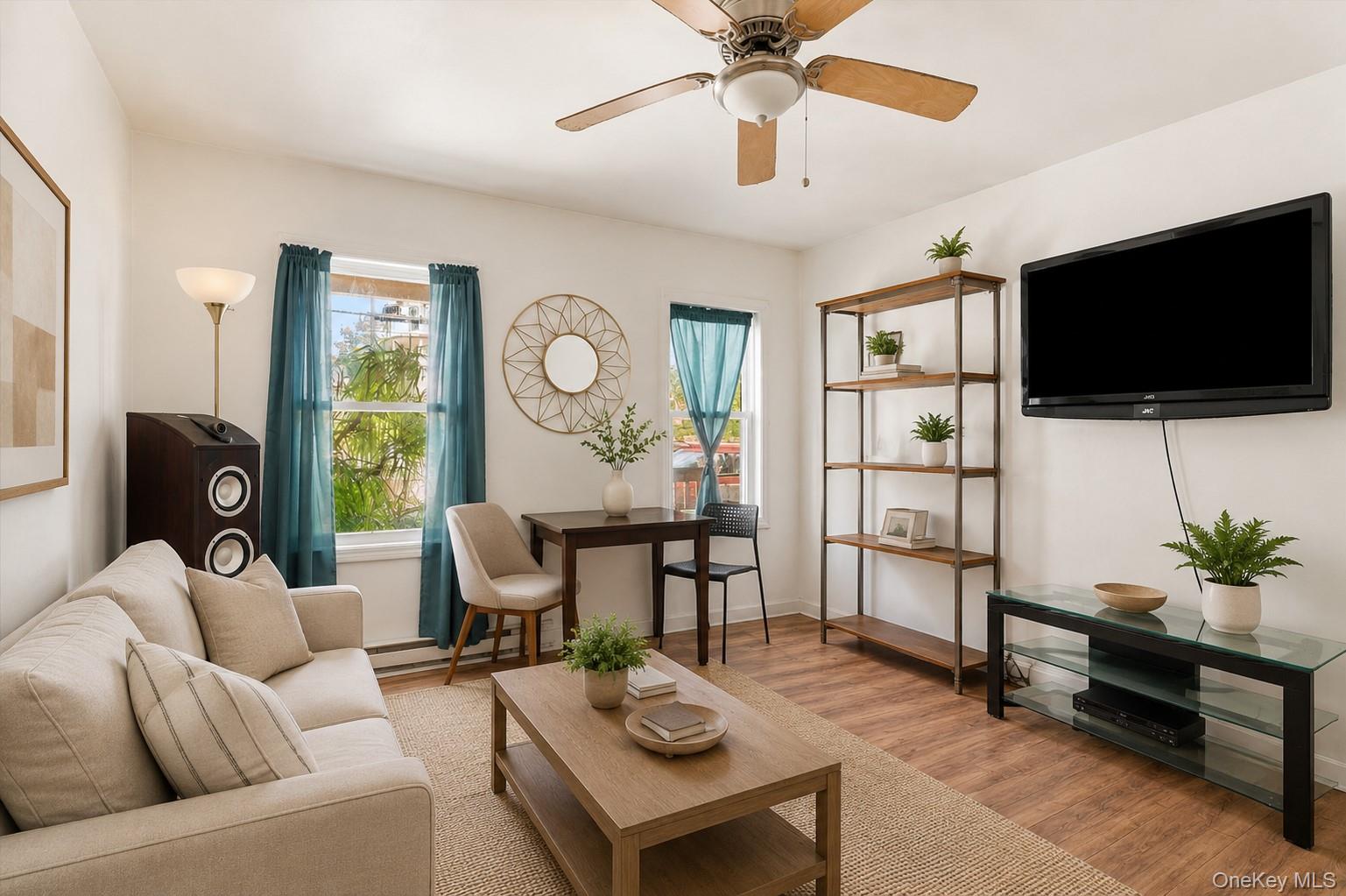 931 Diven Street Peekskill, NY 10566 - Photo 6 of 29 Open concept living area featuring wood-finish flooring, a ceiling fan with integrated lighting, and multiple windows