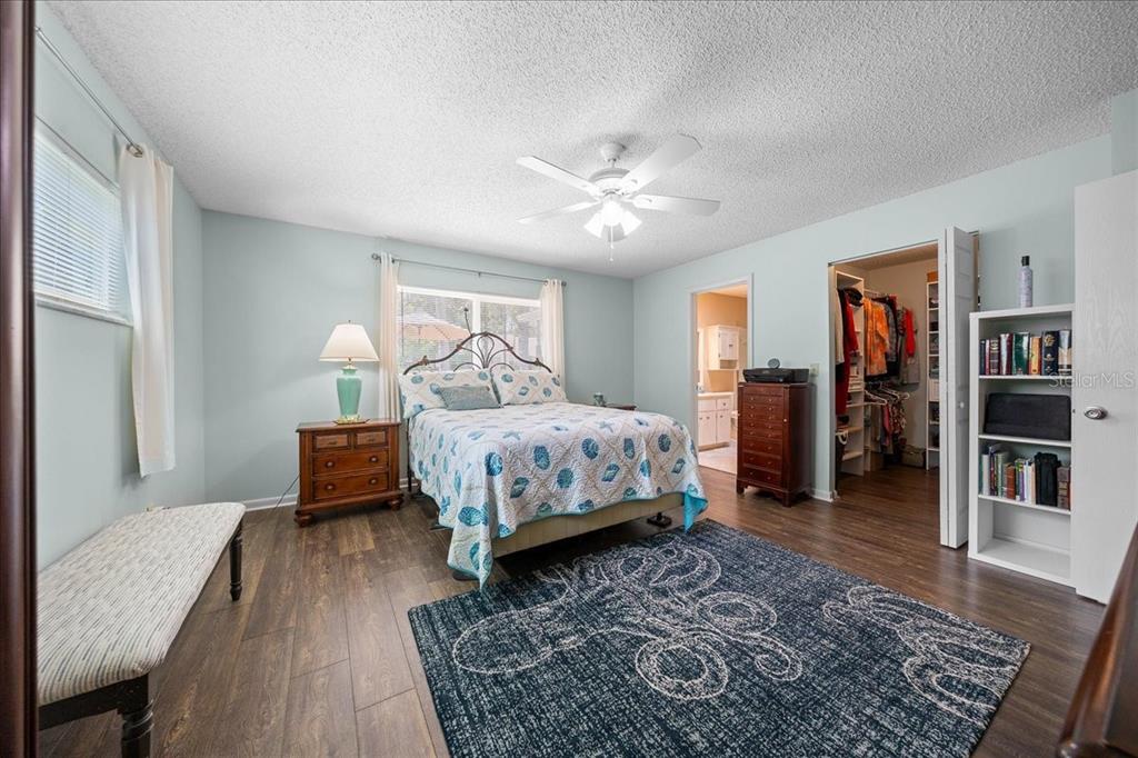 8720 Southwest 90th Street, Unit A Ocala, FL 34481 - Photo 32 of 71 a bedroom with a bed wooden floor and book shelf