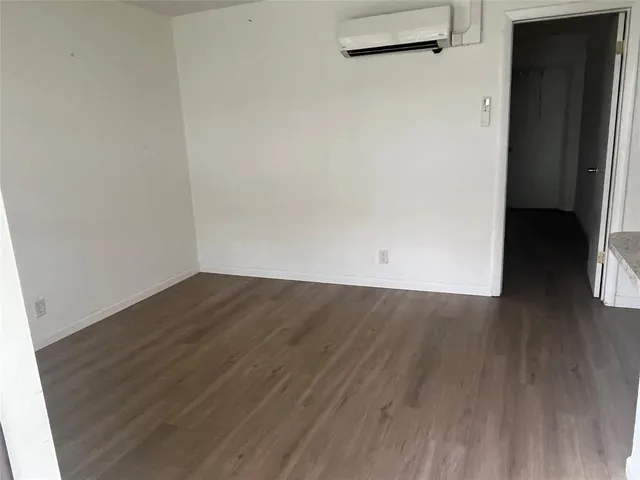 an empty room with wooden floor and a window