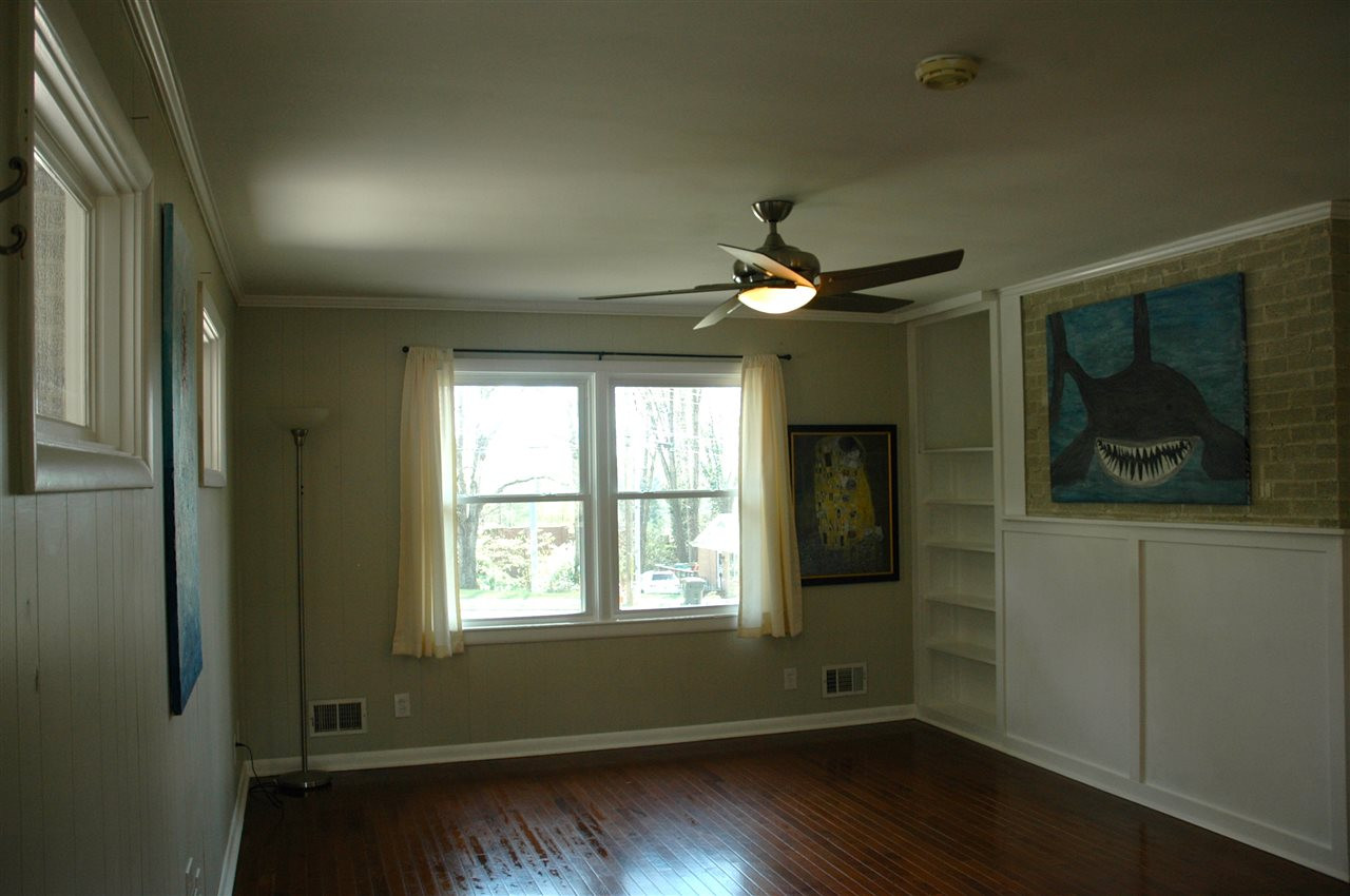 716 Currituck Drive Raleigh, NC 27609 - Photo 7 of 19 Features hardwood floors, paneling, built in bookshelf, & exposed brick accent wall. Family Room