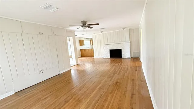 a view of a livingroom with wooden floor and a ceiling fan
