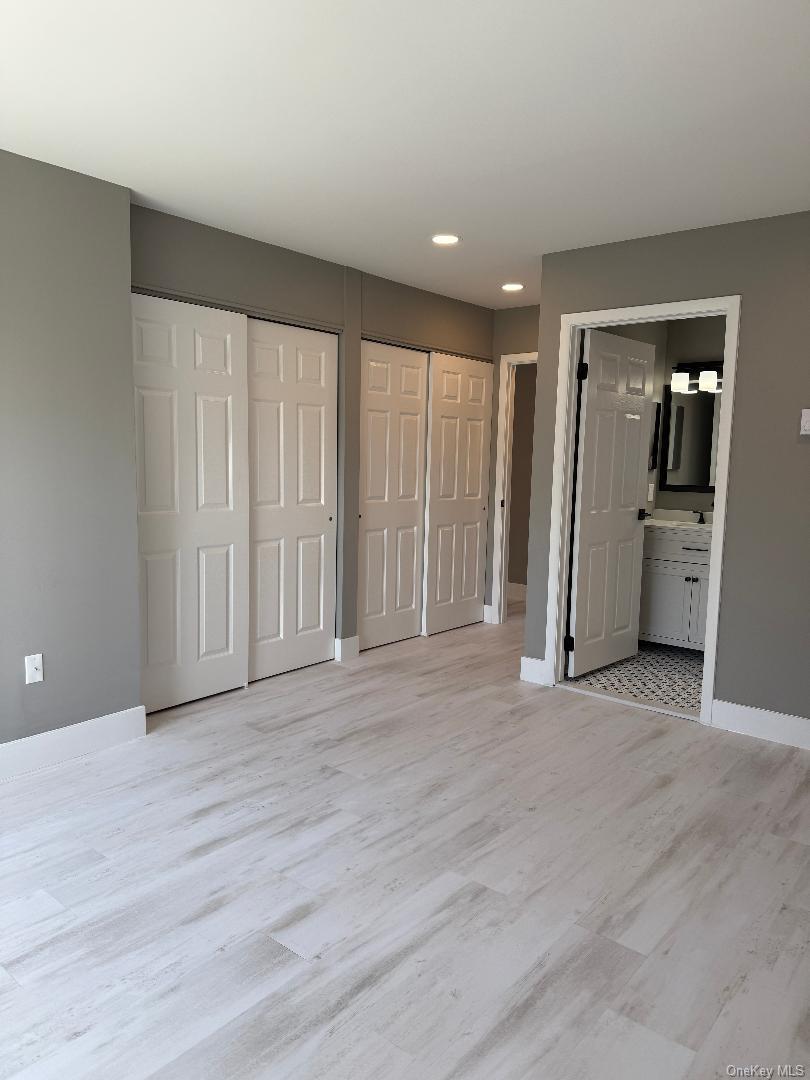 379 Larchmont Court Ridge, NY 11961 - Photo 13 of 17 an empty room with closet and wooden door