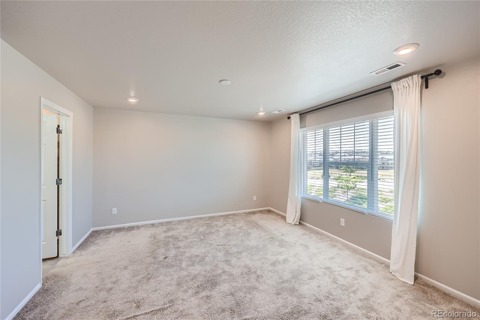 7199 Othello Street Castle Pines, CO 80108 - Photo 14 of 28 a view of an empty room with a window