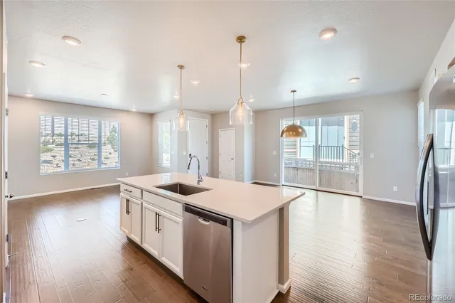 a kitchen that has a sink a stove and wooden floor