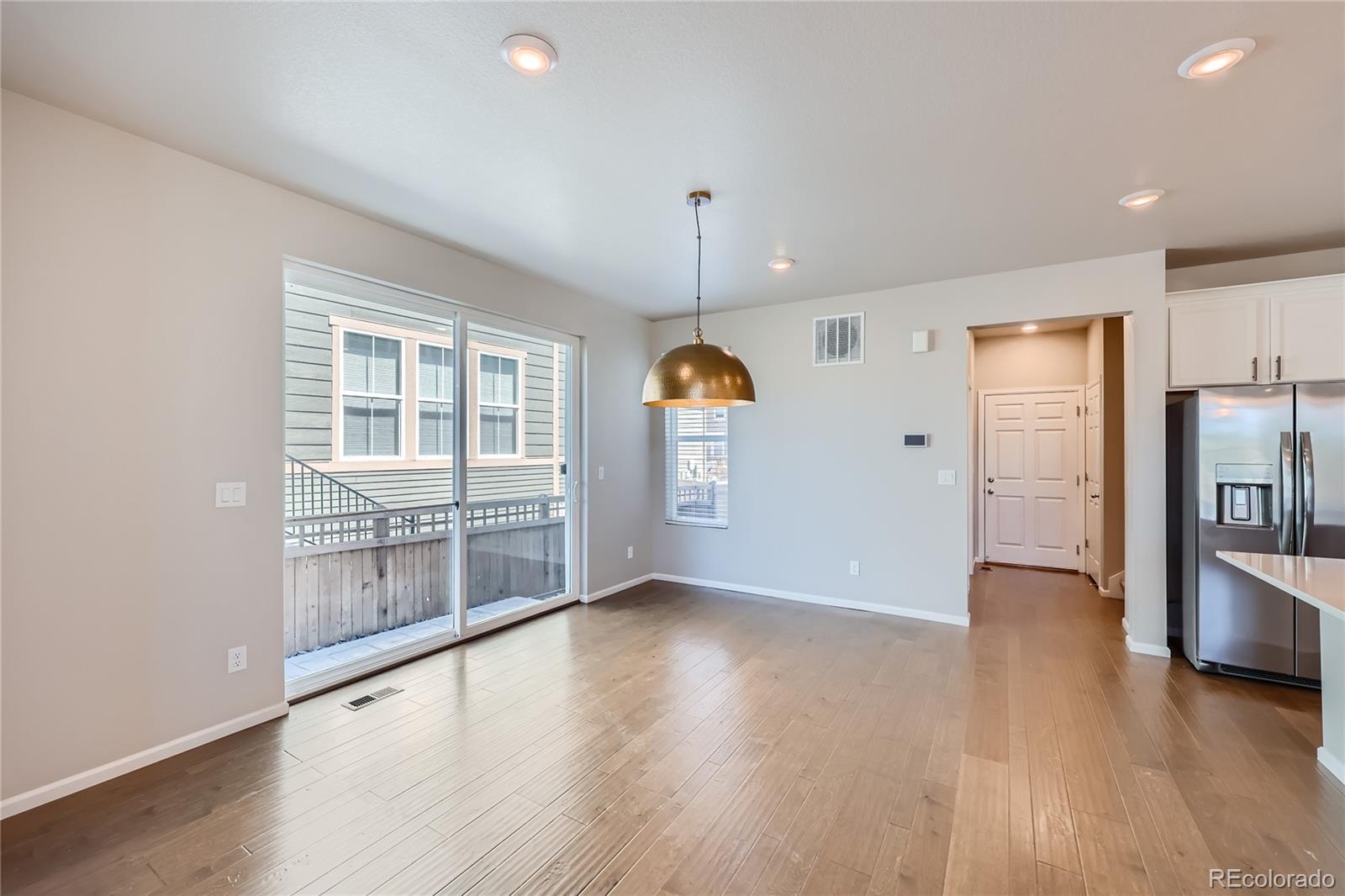 7199 Othello Street Castle Pines, CO 80108 - Photo 9 of 28 wooden floor in an empty room with a window