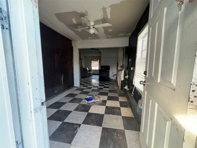 a view of a hallway with a black and white checkered floor