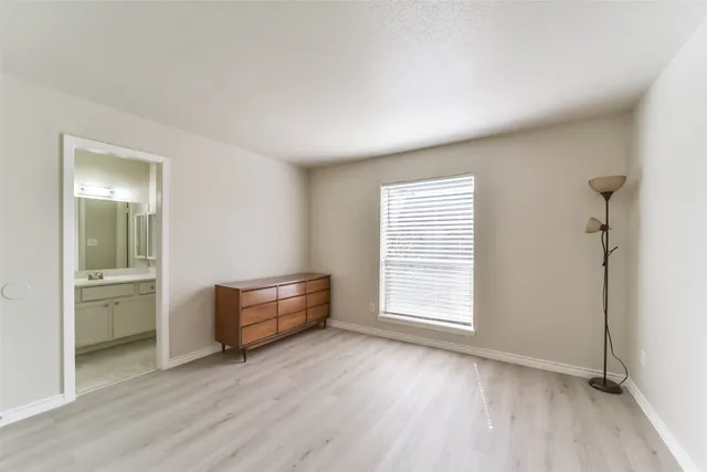 an empty room with a window and wooden floor