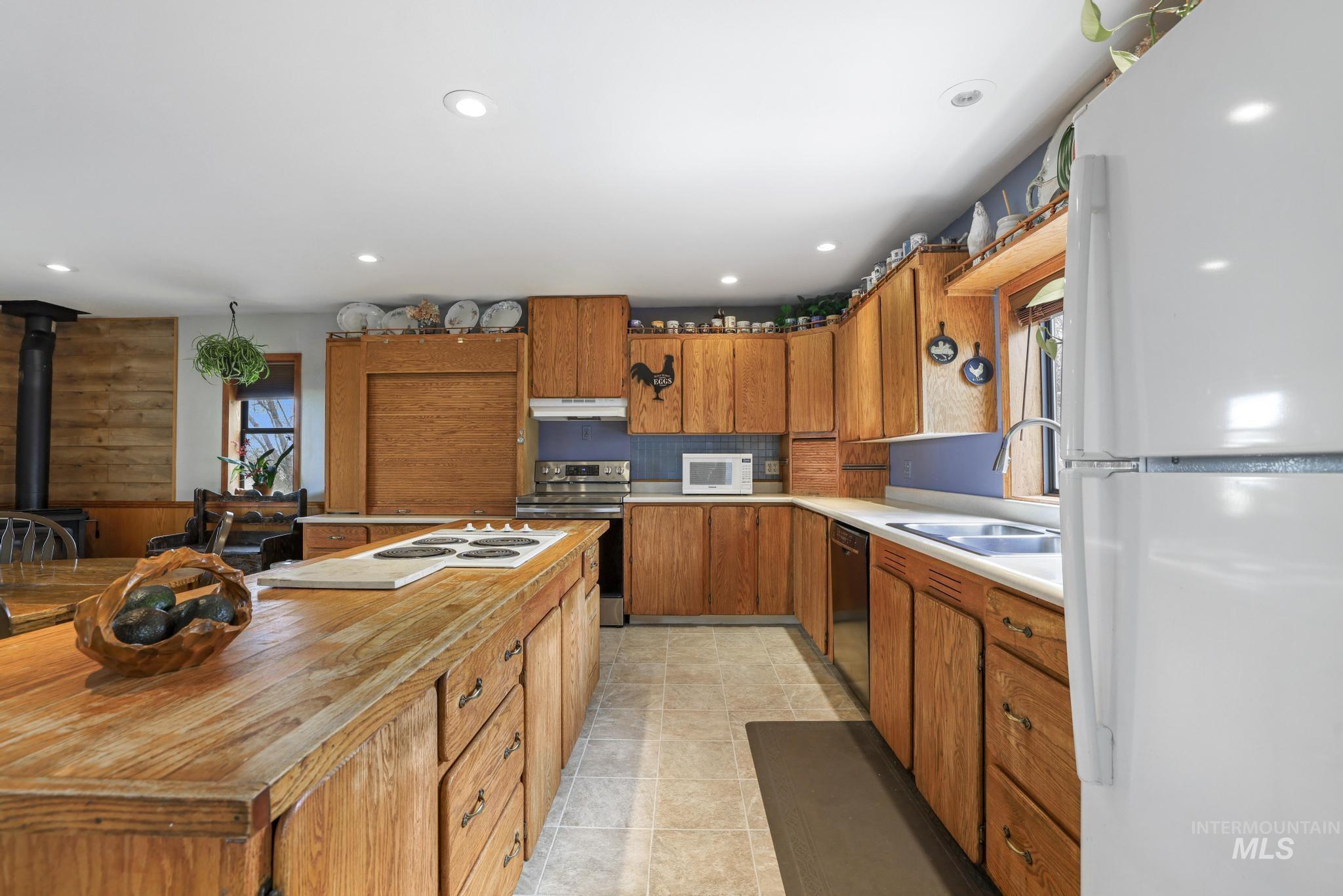 19591 Queen Crown Road Carey, ID 83320 - Photo 7 of 37 Kitchen featuring extensive wood cabinetry, a large wood island with integrated cooktop, recessed lighting, and tile flooring