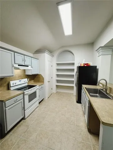 a kitchen with granite countertop a stove sink and cabinets