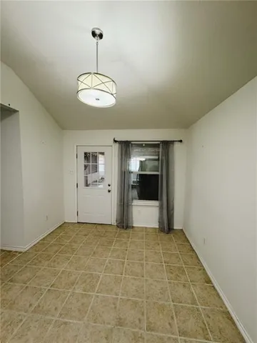 a view of an empty room with window and cabinet