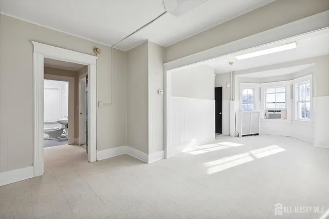 a view of a livingroom with wooden floor and a bathroom