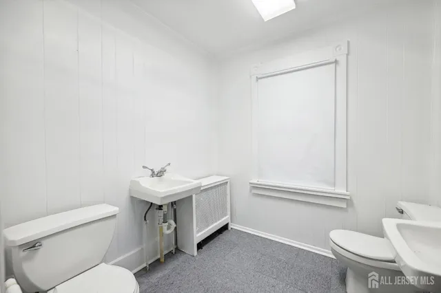 a bathroom with a sink a toilet and a mirror
