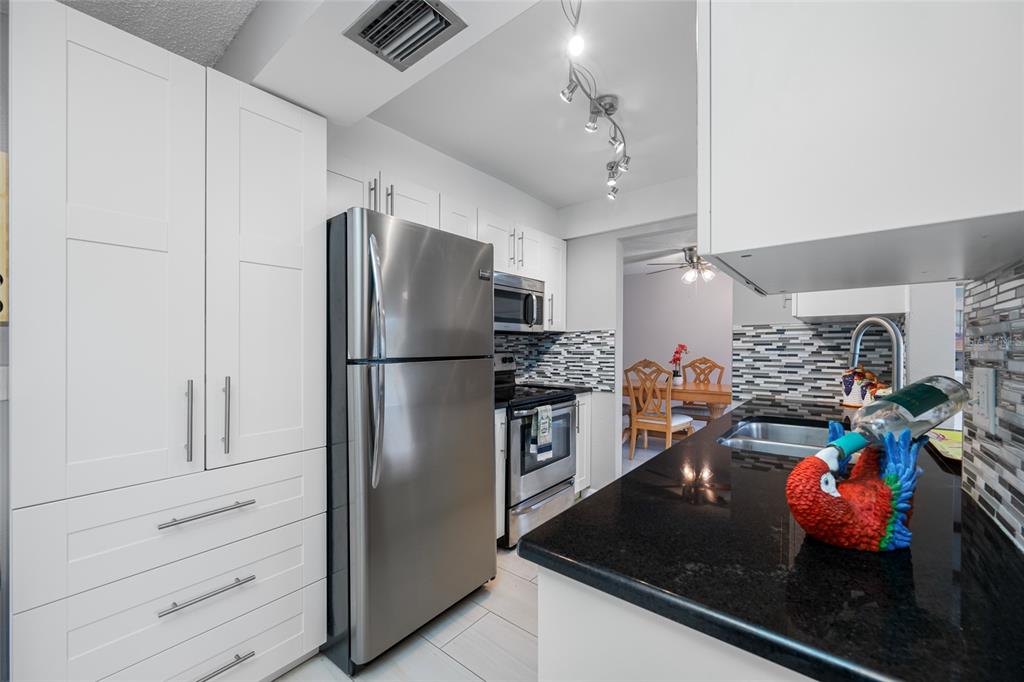 12200 Vonn Road, Unit 8A Largo, FL 33774 - Photo 16 of 41 a kitchen with stainless steel appliances granite countertop a refrigerator and a stove