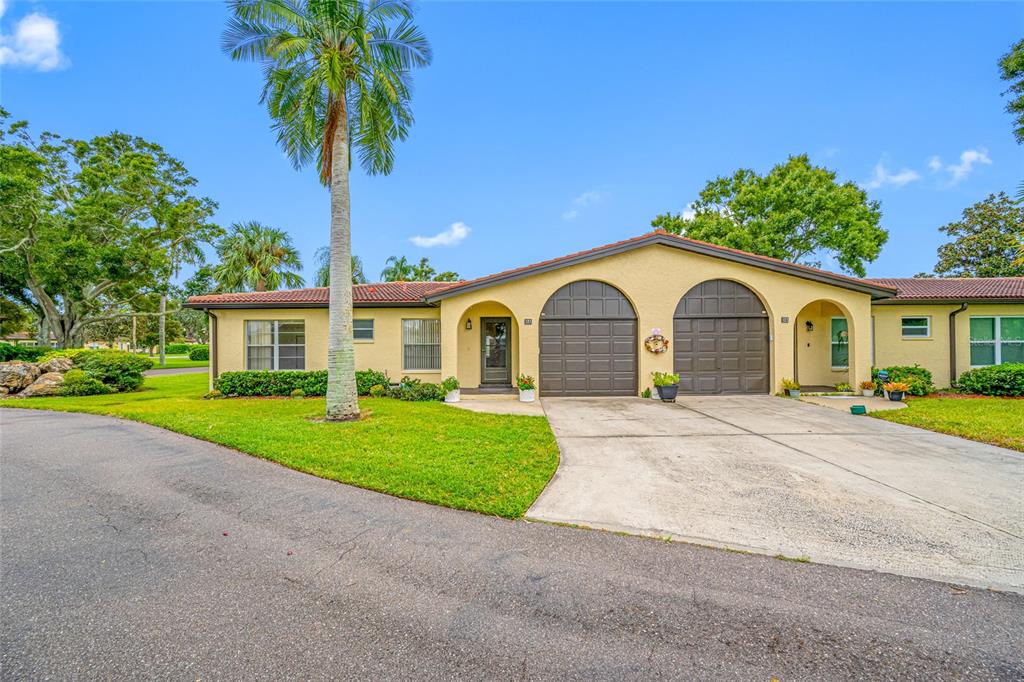 12200 Vonn Road, Unit 8A Largo, FL 33774 - Photo 2 of 41 a view of a house with a yard and palm trees