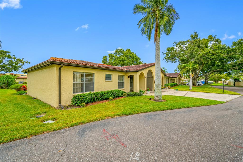 12200 Vonn Road, Unit 8A Largo, FL 33774 - Photo 3 of 41 a view of a house with a yard and palm trees