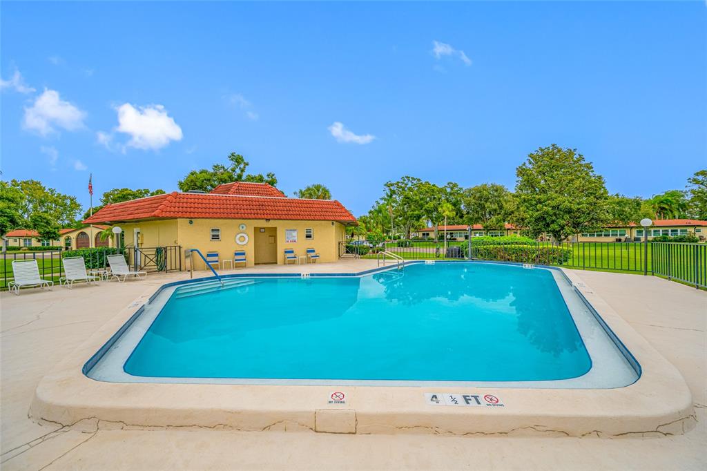 12200 Vonn Road, Unit 8A Largo, FL 33774 - Photo 8 of 41 a view of swimming pool with lawn chairs under an umbrella